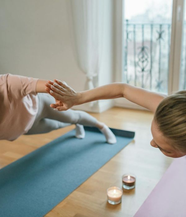 Woman performing a gentle yoga stretch in a bright room.